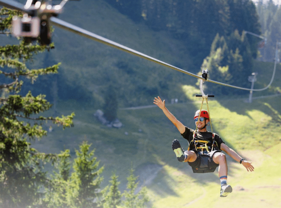 Mann fährt mit Zipline bergab.